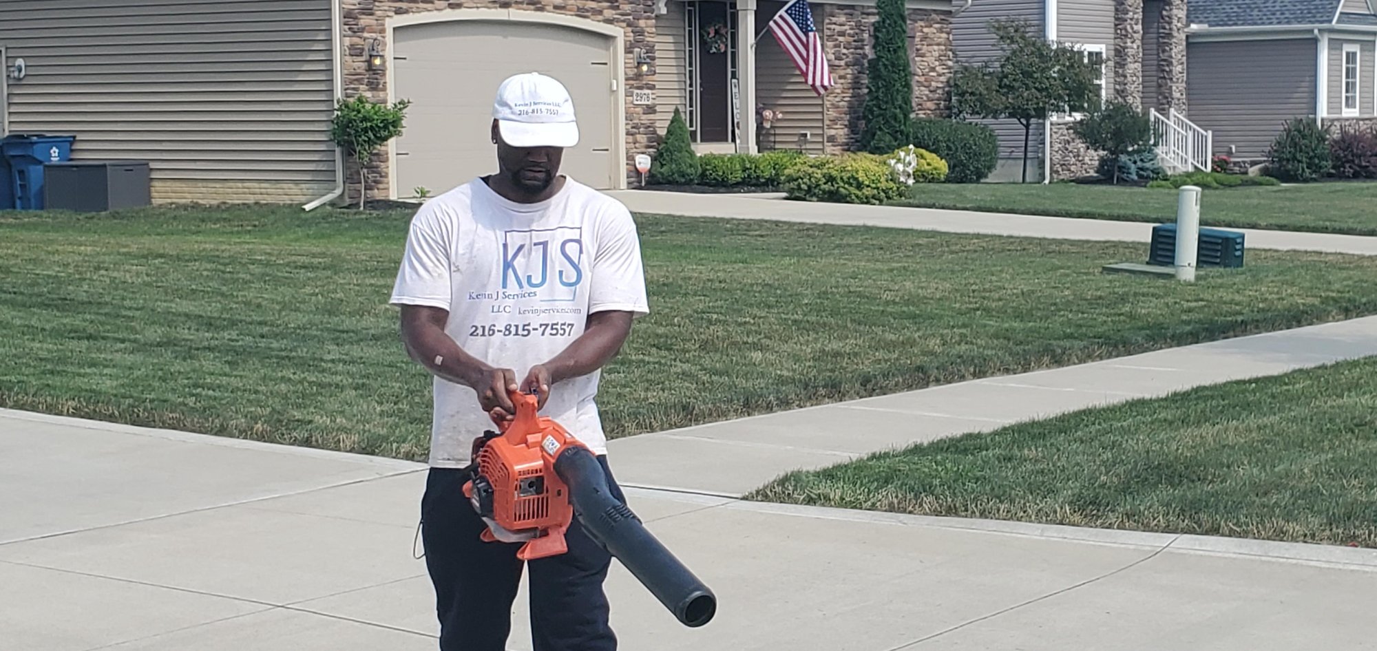 Kevin J Services employee holding a leaf blower after mowing a lawn near Euclid, Ohio